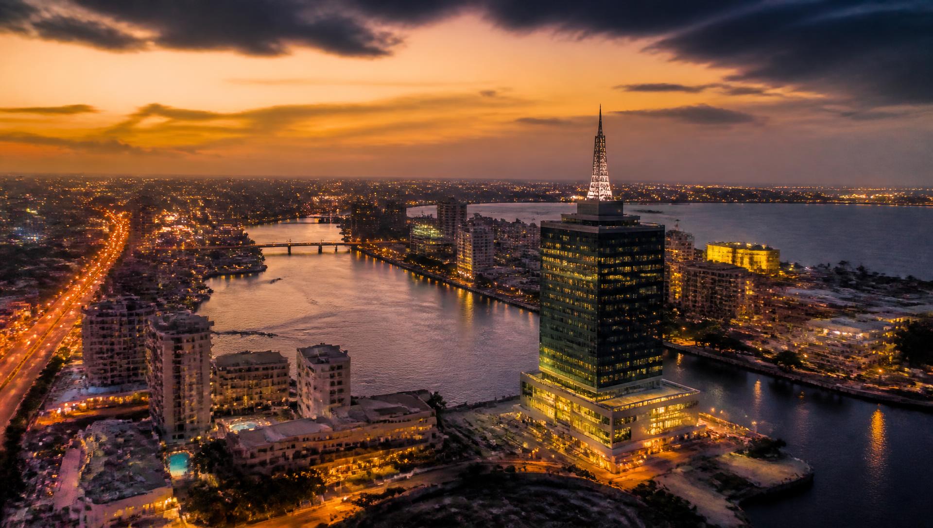 Aerial view of the Lagos skyline and lagoon at dusk with warm golden light
